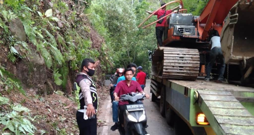 Longsor Batu Lobang Petugas Sat Lantas Polres Tapteng Mengatur Arus Lalu Lintas di Lokasi.